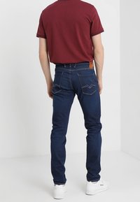 Mörkblå denimjeans med smal passform, som har två bakfickor, kontrasterande sömmar och en liten läderetikett på midjebandet.