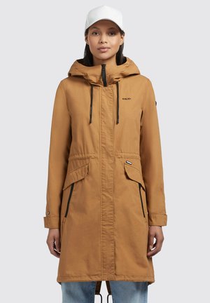 Brown waterproof parka with a hood, front zipper, two large flap pockets, drawstrings at the waist, and a relaxed fit.
