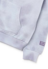 Sweatshirt tie-dye couleur violet clair avec détail de manche et de poche, poignets côtelés, et une petite étiquette en tissu indiquant "SLAY THE by Keep".