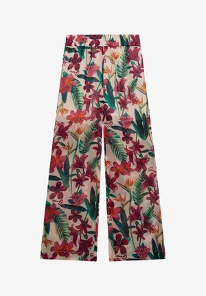 Blommiga byxor med vida ben som har en glänsande finish, elastisk midja och livfulla röda och gröna tropiska mönster på en ljus bakgrund.
