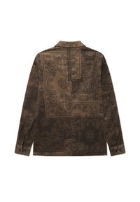 Chaqueta de pana marrón con intrincados patrones florales, que cuenta con un cuello con solapas y puños abotonados, mostrando una superficie texturizada.
