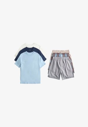 Three short-sleeve t-shirts in light blue, navy, and white stacked next to three pairs of striped elastic waist shorts.