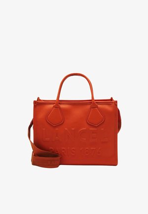 Sac à main en cuir orange avec un logo en relief, forme structurée, deux poignées supérieures et une bandoulière amovible. Texture lisse.