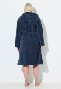 Accappatoio con cappuccio blu navy realizzato in tessuto morbido, caratterizzato da vita legata e maniche lunghe, con una vestibilità comoda e un orlo di lunghezza media.