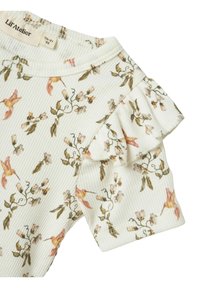 Ziedu raksts bērnu tops ar ribotu tekstūru. Tam ir pastelīgu ziedu un kolibri motīvi uz baltas fona, ar volānu akcentiem.