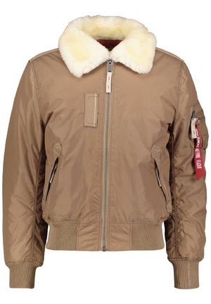 Brun bomberjakke med cremefarvet pelsfor, lynlås foran, ribstrikkede manchetter og kant, lynlåslomme på ærmet med rød mærkat med teksten "Remove Before Flight".