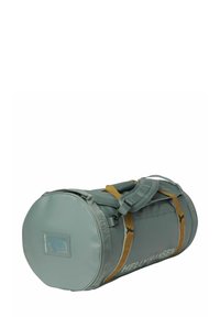 Bolsa tipo duffel redonda en verde apagado con correas en color marrón claro. Cuenta con cierre de cremallera, parche con logotipo y correa de hombro ajustable para mayor versatilidad.