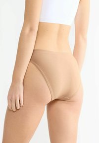 Beige Baumwoll-Höschen mit hoher Taille und nahtlosem Design, minimaler Naht und glatter Textur, von hinten gezeigt.