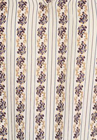Patterned fabric with vertical stripes. Features floral designs in purple and gold against a cream background. Soft, textured material.