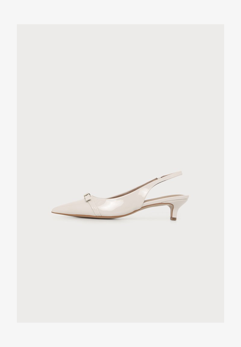 Chaussure slingback beige brillante à bout pointu avec un petit talon kitten et une petite boucle métallique près de l’orteil.