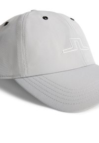 Grå keps i texturerad tyg med en solid skärm, svarta öglor och en vit logotyp på framsidan.