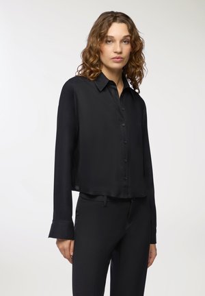 Camicia nera a maniche lunghe con bottoni, realizzata in un tessuto leggero e morbido, con una vestibilità rilassata e maniche con polsini. Nessun motivo o dettaglio visibile.