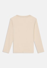 Beige langermet t-skjorte med rund hals, enkel design, vist flatt med baksiden opp på en hvit bakgrunn.