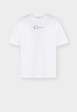 Hvid T-shirt med korte ærmer med lille blåt cirkulært motiv og teksten "THE AFTER GLOW" på øverste del af brystet.