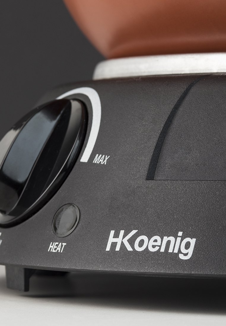 Schwarzer elektrischer Sockel mit einem Steuerknopf, der mit "MAX" beschriftet ist, und einer Anzeige für "HEAT". Das Design ist grau und silber.