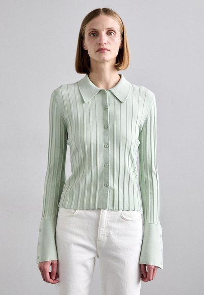 Muntgroene geribde cardigan met een kraag, knopen aan de voorkant en lange mouwen met bredere manchetten en knoopaccenten.