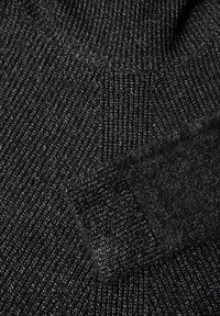 Schwarzer Strickpullover mit einem strukturierten Rippenmuster, der einen hohen Kragen und ein etwas dunkleres Bündchendetail aufweist.