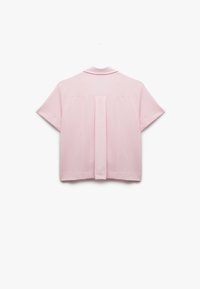 Maglietta rosa a maniche corte con tessuto testurizzato, colletto e dettaglio della piega sul retro per un design aggiuntivo.