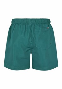 Zaļie peldšorti, kas izgatavoti no viegla materiāla, ar elastīgu jostasvietu, mugurējo kabatu un vienkāršu dizainu bez rakstiem.