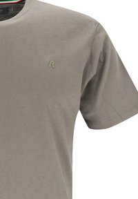 Ljusgrå t-shirt i mjuk bomull med rund halsringning, korta ärmar och en diskret logotyp på bröstet. Mjuk textur och enkel design.