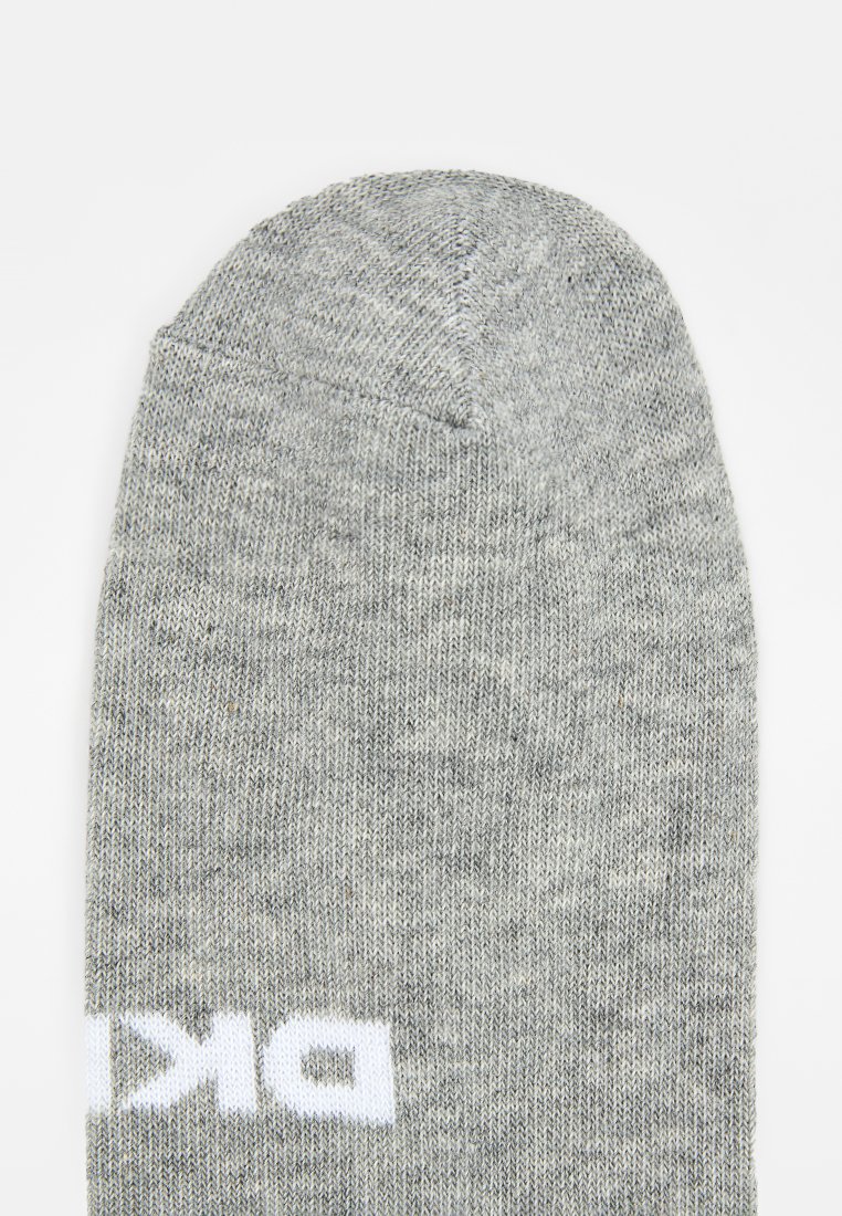 Szara skarpetka o gładkiej fakturze i zaokrąglonym palcu. Posiada białe logo z boku, tkaninę dziewiarską z melanżowym wzorem.