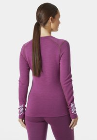 Dlouhá rukávová sportovní bunda v živé fialové barvě s texturovanou tkaninou, kontrastními švy a bílými akcentními pruhy na manžetách.