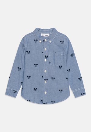 Chemise bleu clair à manches longues avec petits motifs de tête de Mickey Mouse noirs et une poche poitrine à l'avant.