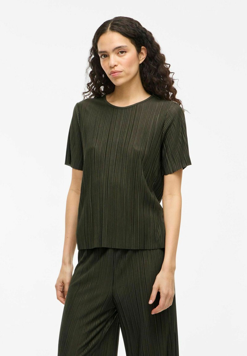 Top plissettato verde scuro con scollatura rotonda e maniche corte, caratterizzato da una texture liscia e una vestibilità rilassata.