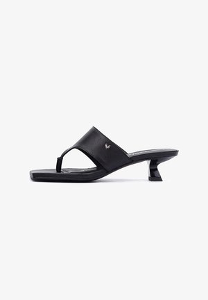 Sandalias de tacón negras de cuero con una banda ancha y diseño con tira entre los dedos. Presentan un tacón de bloque y un detalle sutil del logo en la banda.