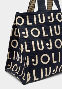 Borsa tote in tessuto blu navy con grande scritta color crema, "LIU JO", tessuto strutturato e manici larghi a righe.