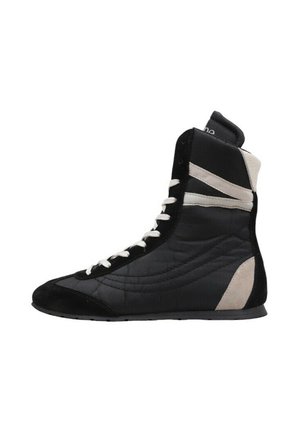 Zapatilla deportiva de caña alta en blanco y negro con cordones blancos, paneles laterales acolchados y suela de goma plana mostrada de perfil derecho.