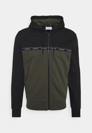 Felpa con cappuccio zip black e verde oliva, caratterizzata da un design a contrasto con una bandiera logo sul petto e polsini a coste.