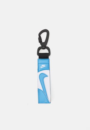 Portachiavi Nike con una cinghia in pelle blu e bianca, caratterizzato da un grande logo swoosh bianco, attaccato a un gancio nero per un facile attacco.