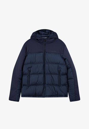 Giacca puffy blu navy con cappuccio, caratterizzata da un design trapuntato, tasche laterali con zip e un pannello superiore liscio.