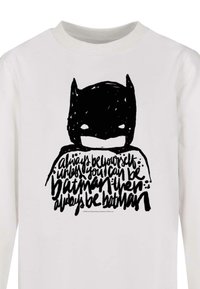 White long-sleeve shirt featuring a black graphic of a batman face and handwritten text: "always be yourself unless you can be Batman..."