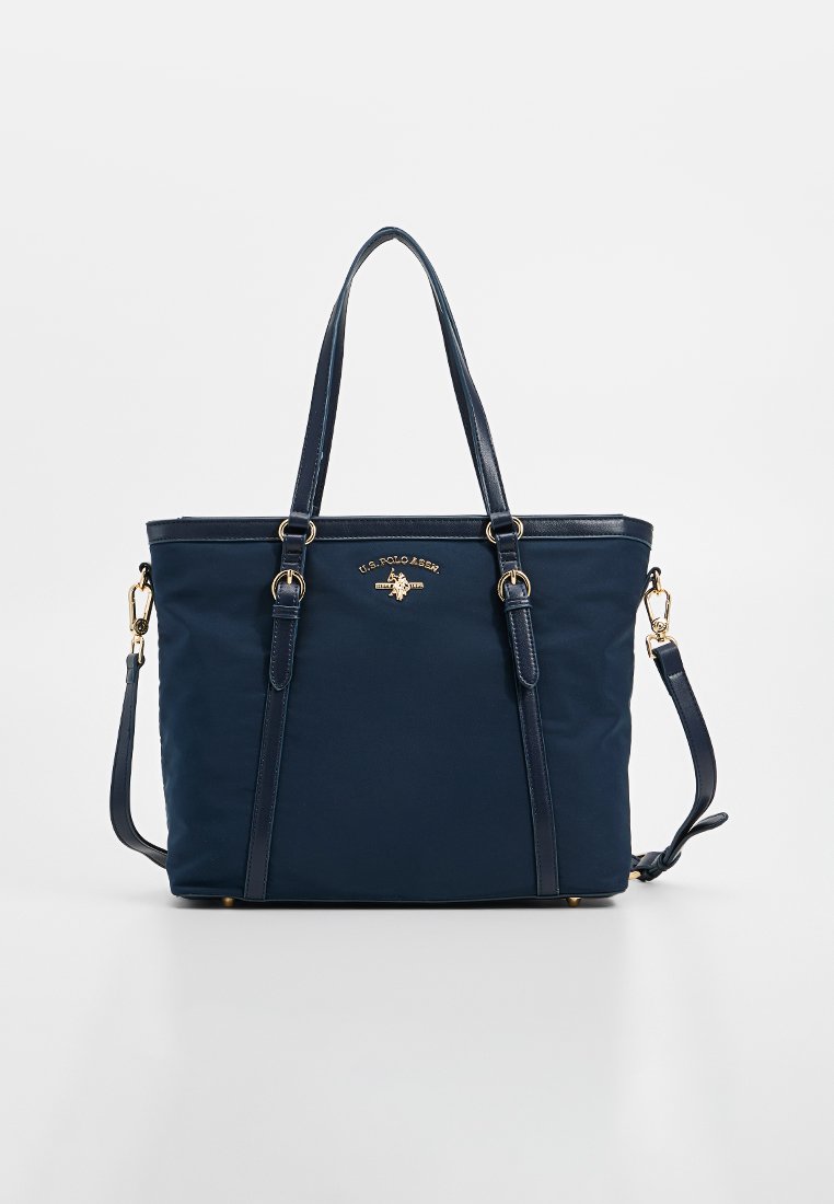 Sac fourre-tout en nylon bleu marine avec doubles poignées. Il présente des éléments en métal doré et un logo. Conception structurée avec une bandoulière détachable.