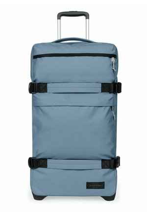 Maleta azul de carcasa blanda con ruedas, asa telescópica, bolsillo frontal con cremallera y dos correas negras ajustables.