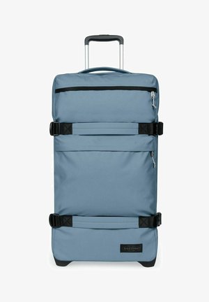 Valigia blu in soft-shell con ruote, manico telescopico, tasca frontale con cerniera e due cinghie nere regolabili.