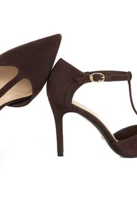 Chaussures à talons hauts en daim marron avec un bout pointu, des découpes sur les côtés, une bride à la cheville et une petite boucle dorée.