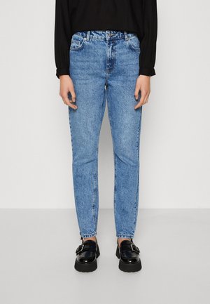 Lichtblauwe denim jeans met een slim fit, met vijf zakken en een tailleband. Draagt bij zwarte platform loafers.