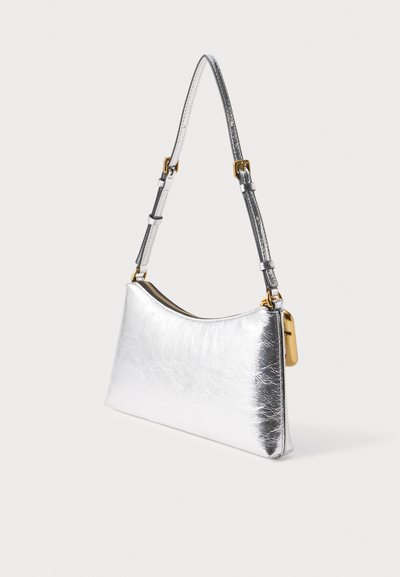Petit sac à main métallique argenté avec bandoulière réglable, fermeture éclair dorée et détail de cadenas doré sur un fond clair uni.