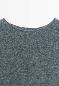 Close-up of the neck and upper chest area of a gray knitted wool sweater with a rounded neckline.