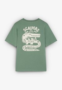 Vihreä puuvillapaita, jossa on suuri valkoinen graafinen kuvasto krokotiilista, teksti "S.CALPERS WILD AND FREE" ja "Tervetuloa kesäleirille."