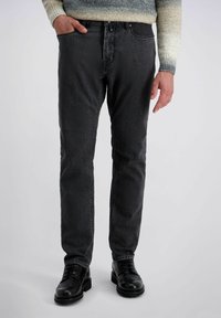 Donkergrijze denimjeans met een rechte fit, voorzien van een knoopsluiting, steekzakken en een subtiele textuur. Gecombineerd met zwarte leren schoenen.