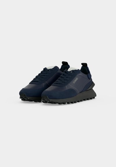 Paire de baskets basses bleu foncé avec semelles épaisses noires et lacets, avec le logo "ICEBERG" sur le côté.