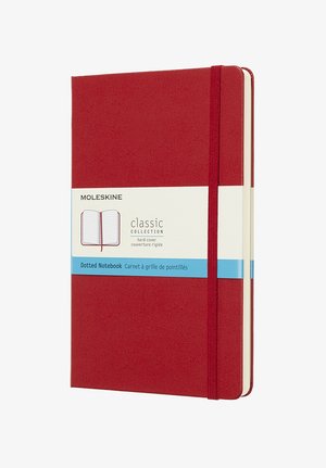 Quaderno rigido Moleskine di colore rosso con pagine a pois. Presenta una chiusura elastica e un'etichetta che dettagli la collezione classica.