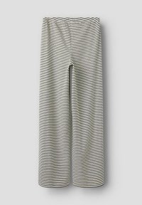 Pantalons larges à rayures noires et blanches avec une taille élastique, fabriqués en tissu doux, présentant une texture lisse et une coupe ample.