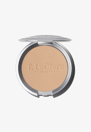 Compact powder in a silver circular case. The powder surface is beige with an embossed logo, featuring a flat texture and smooth finish.