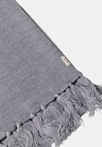 Sciarpa grigia intrecciata con dettagli in frangia su un lato. Il tessuto presenta una sottile texture a coste. Caratterizzata da un piccolo etichetta di marca vicino alla frangia.