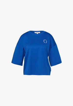 Helles blaues, kurzärmeliges, übergroßes T-Shirt mit rundem Ausschnitt und kleiner weißer kreisförmiger Schriftgestaltung auf der linken Brustseite.